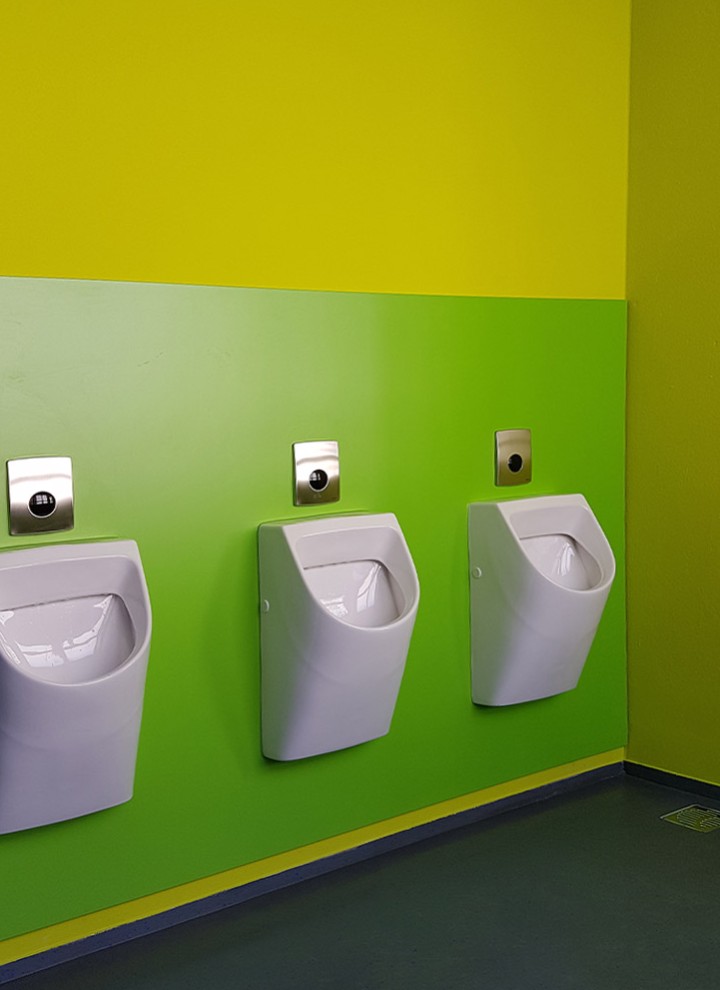 Moderne Farbgestaltung mit Gelb und Grün in der Jungentoilette
